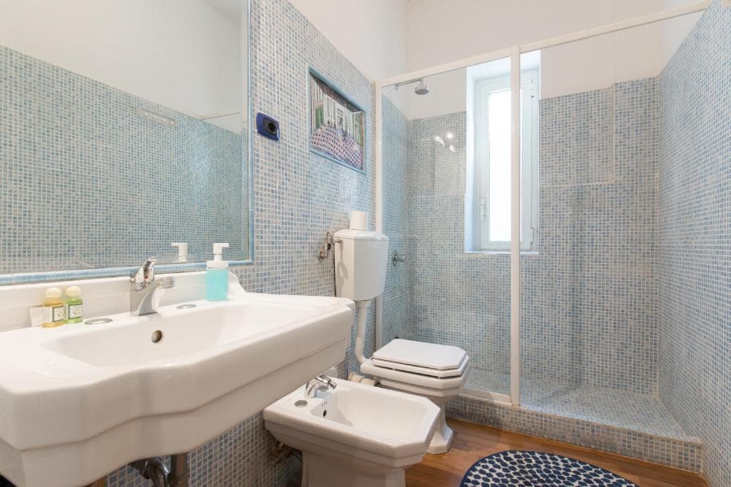 Bathroom with walk-in shower, WC, bidet and blue mosaic tiling